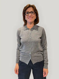 Polo donna in lana merino grigia indossata, con colletto, bottoni frontali