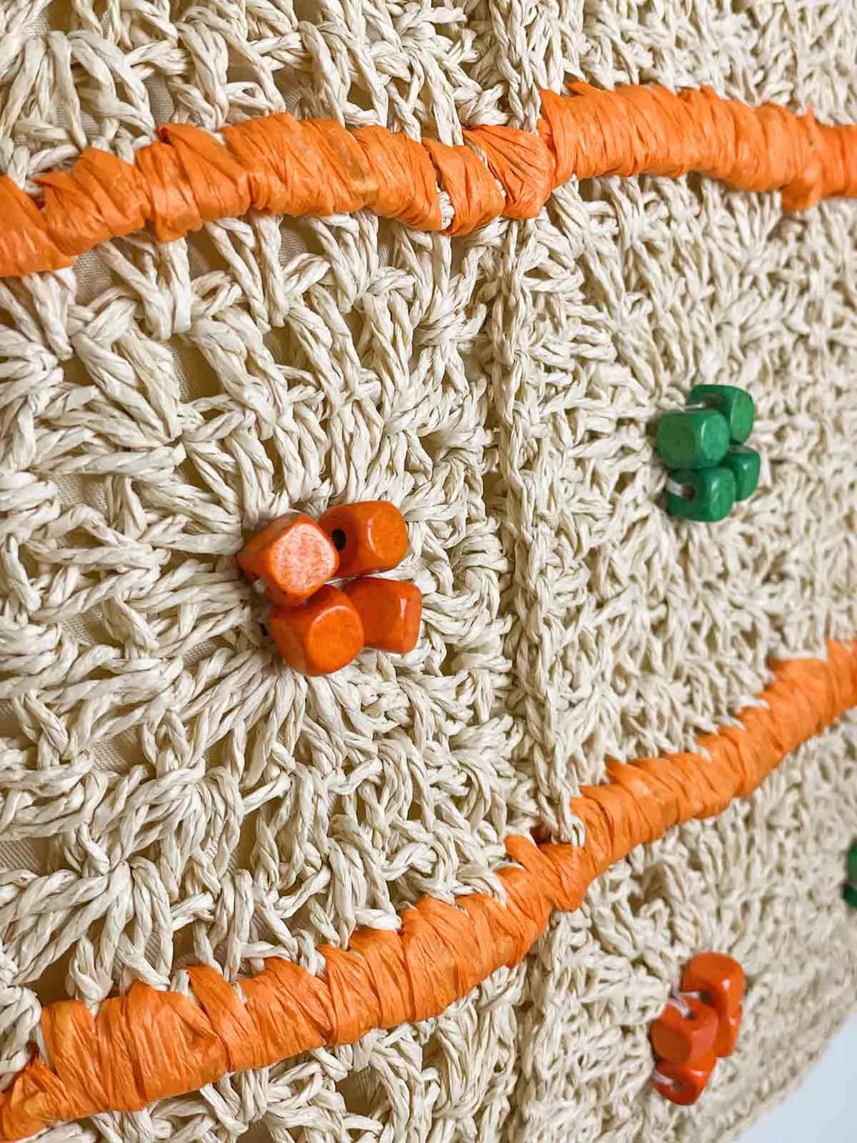Borsa a uncinetto in Rafia naturale, raffinata trama a quadri e decorata con dettagli di Rafia Arancio e perline in legno colorate di Arancio e Verde a contrasto