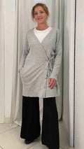 Cardigan lungo in lana merino grigio mélange da donna, con scollo a V e bottoni, indossato con pantaloni neri ampi